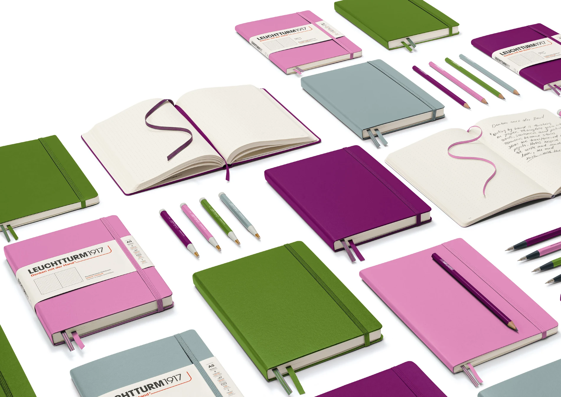 The 2027 notebook collection in Burgundy, Bubblegum, Moss and Dove, with open journals and coordinating accessories